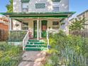 Inviting covered front porch with green accents and a well-manicured garden in front of the property at 1612 N High St, Denver, CO 80218