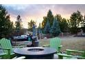 Enjoy outdoor gatherings with a fire pit and Adirondack chairs in a well-maintained backyard at 5893 Lasso Pl, Parker, CO 80134