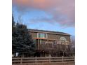 Enjoy the view and a large patio from this large home surrounded by mature trees and a wooden fence at 20460 Oakbrook Ln, Parker, CO 80138