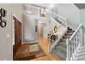 Grand entryway featuring a staircase with white railings, chandelier, and a view of the upper level at 20460 Oakbrook Ln, Parker, CO 80138