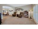 Comfortable living room featuring plush leather armchairs, a bookshelf, and bright window shutters at 20460 Oakbrook Ln, Parker, CO 80138