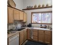 Kitchen with light wood cabinets, stainless sink and window with a forest view at 10314 Red Fern Trl, Conifer, CO 80433