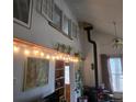Cozy living room featuring a wood burning stove, exposed beam, and decorative string lights at 10314 Red Fern Trl, Conifer, CO 80433