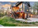Lovely exterior view of home with stone accents, deck, and lush landscape at 5090 S Perry Park, Sedalia, CO 80135