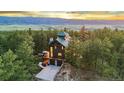 Stunning exterior view of a wood-sided home nestled amongst trees with a mountain view at 5090 S Perry Park, Sedalia, CO 80135