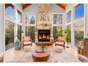 Cozy living room with stone fireplace, vaulted ceilings, and scenic views through large windows at 5090 S Perry Park, Sedalia, CO 80135