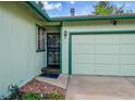 Close-up showcasing the home's front door, garage, and manicured front lawn at 1669 S Uvalda St, Aurora, CO 80012