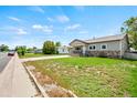 Charming home featuring stone accents, well-maintained lawn, and a driveway leading to a garage at 335 N 11Th Ave, Brighton, CO 80601