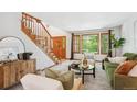Bright living room with staircase, wooden door, large windows, and comfortable furnishings at 16177 E Prentice Pl, Centennial, CO 80015