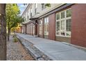 Brick building exterior with sidewalk and landscaping at 800 E 18Th Ave # 105, Denver, CO 80218