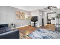 Living room includes a comfy couch, large TV, and wood-look floors at 63 S Sable Blvd # 16, Aurora, CO 80012