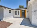 Inviting front entrance featuring a black front door and a freshly poured concrete pad at 3082 S Florence Ct, Denver, CO 80231