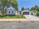 Attractive home with a well-manicured lawn and modern garage door with black trim at 3082 S Florence Ct, Denver, CO 80231