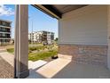 View from the covered front porch of a home showcasing landscaping and surrounding apartment buildings at 1443 Great Western Dr, Longmont, CO 80501
