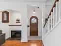 Inviting foyer with hardwood floors, a fireplace, and an arched doorway showcasing architectural charm at 474 S Gaylord St, Denver, CO 80209