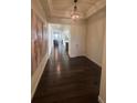 Inviting entry featuring hardwood floors, elegant lighting, decorative wall art, and views of other rooms at 8163 S Valleyhead Way, Aurora, CO 80016