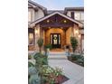 Elegant front entry with stonework, a black door, and landscaping at 1365 Gentry Pl, Castle Rock, CO 80104