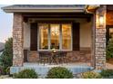 Small table and chairs on a covered porch with stone columns at 1365 Gentry Pl, Castle Rock, CO 80104