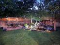 Backyard featuring a water feature and ambient lighting on a stone patio and green grass at 15498 E Dorado Pl, Centennial, CO 80015