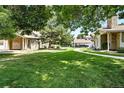 Exterior yard view with mature trees and manicured lawns at 8422 Everett Way # C, Arvada, CO 80005