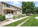 Beautiful townhome exterior with charming courtyard, flowers, and a well-manicured lawn at 8422 Everett Way # C, Arvada, CO 80005