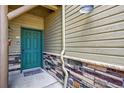 Charming front entryway with craftsman-style door, stone accents, and a welcoming doormat at 31112 Black Eagle Dr # 103, Evergreen, CO 80439