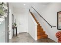 Bright entryway features tile flooring, wooden stairs, and a white door leading outside creating a welcoming space at 3414 W 18Th Ave, Denver, CO 80204