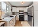 Modern kitchen featuring white cabinets, sleek countertops, stainless steel appliances, and ample natural light at 3798 E 118Th Way, Thornton, CO 80233