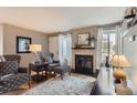 Comfortable living room with stylish armchairs, a decorative fireplace, and natural light from a large window at 3798 E 118Th Way, Thornton, CO 80233