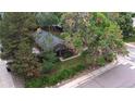 An aerial view of the cozy home surrounded by mature trees and a neatly kept yard at 1703 W Weaver Ave, Littleton, CO 80120