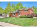 Traditional brick home boasts a well-manicured lawn, mature landscaping, and a welcoming front entrance at 503 Lois Dr, Louisville, CO 80027