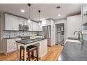 Bright kitchen featuring white cabinets, stainless steel appliances, and an island with barstool seating at 503 Lois Dr, Louisville, CO 80027