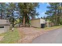View of the garage, parking area and backyard of a charming single Gathering home at 26351 Sheldon St, Kittredge, CO 80457