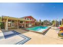 Backyard pool with a slide, surrounded by a patio, creating an ideal outdoor retreat at 15373 Uravan St, Brighton, CO 80601
