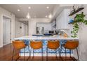 Modern kitchen featuring a waterfall island with bar seating and white shaker cabinets at 1488 Madison St # 307, Denver, CO 80206