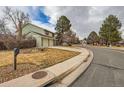 Attractive two-story home with a well-maintained lawn and two car garage on a cloudy day at 8155 Everett E St, Arvada, CO 80005