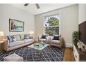 Bright living room featuring stylish furnishings, a ceiling fan, and a large window at 351 Bannock St, Denver, CO 80223