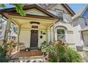 Inviting front porch with seating, mature trees and beautiful landscaping leading to the front door at 351 Bannock St, Denver, CO 80223