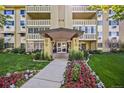 Condominium entrance with manicured landscaping featuring colorful flowers and green plants at 610 S Alton Way # 7C, Denver, CO 80247