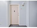 Apartment hallway leading to a door with modern light fixture and neutral decor at 610 S Alton Way # 7C, Denver, CO 80247