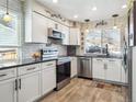 Modern kitchen featuring white cabinets, stainless steel appliances, and stylish subway tile backsplash at 7344 S Sheephorn Mtn, Littleton, CO 80127