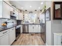 Bright kitchen featuring white cabinets, stainless steel appliances, and a cozy eat-in area at 7344 S Sheephorn Mtn, Littleton, CO 80127