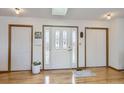 Entryway featuring wood floors, white walls, and a decorative glass door with white trim at 1901 Blue Mountain Ave, Berthoud, CO 80513