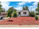 Charming home with white siding and a front yard covered with reddish mulch at 1925 Syracuse St, Denver, CO 80220
