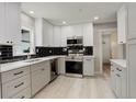 Modern kitchen with white cabinets, stainless steel appliances, and black backsplash at 1925 Syracuse St, Denver, CO 80220
