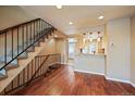 Inviting living area featuring hardwood floors, a staircase, and kitchen access at 9659 W Cornell Pl, Lakewood, CO 80227