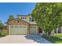 Charming two-story home featuring a stone facade, three-car garage, and mature landscaping at 13962 Dexter Way, Thornton, CO 80602