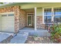 Inviting covered front porch with stone accents and vibrant flowers at 13962 Dexter Way, Thornton, CO 80602