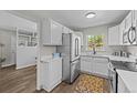 Bright kitchen features white cabinets, stainless steel appliances, and a window with a view at 957 Newton St, Denver, CO 80204