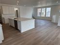 Bright, open-concept kitchen features a large center island, stainless steel appliances, and wood flooring at 7276 Waterleaf Trl, Littleton, CO 80125